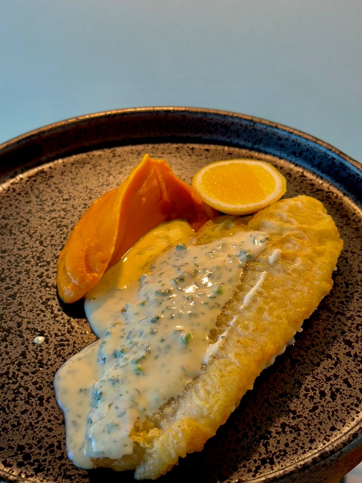 Pan-seared white fish with light sauce and greens
