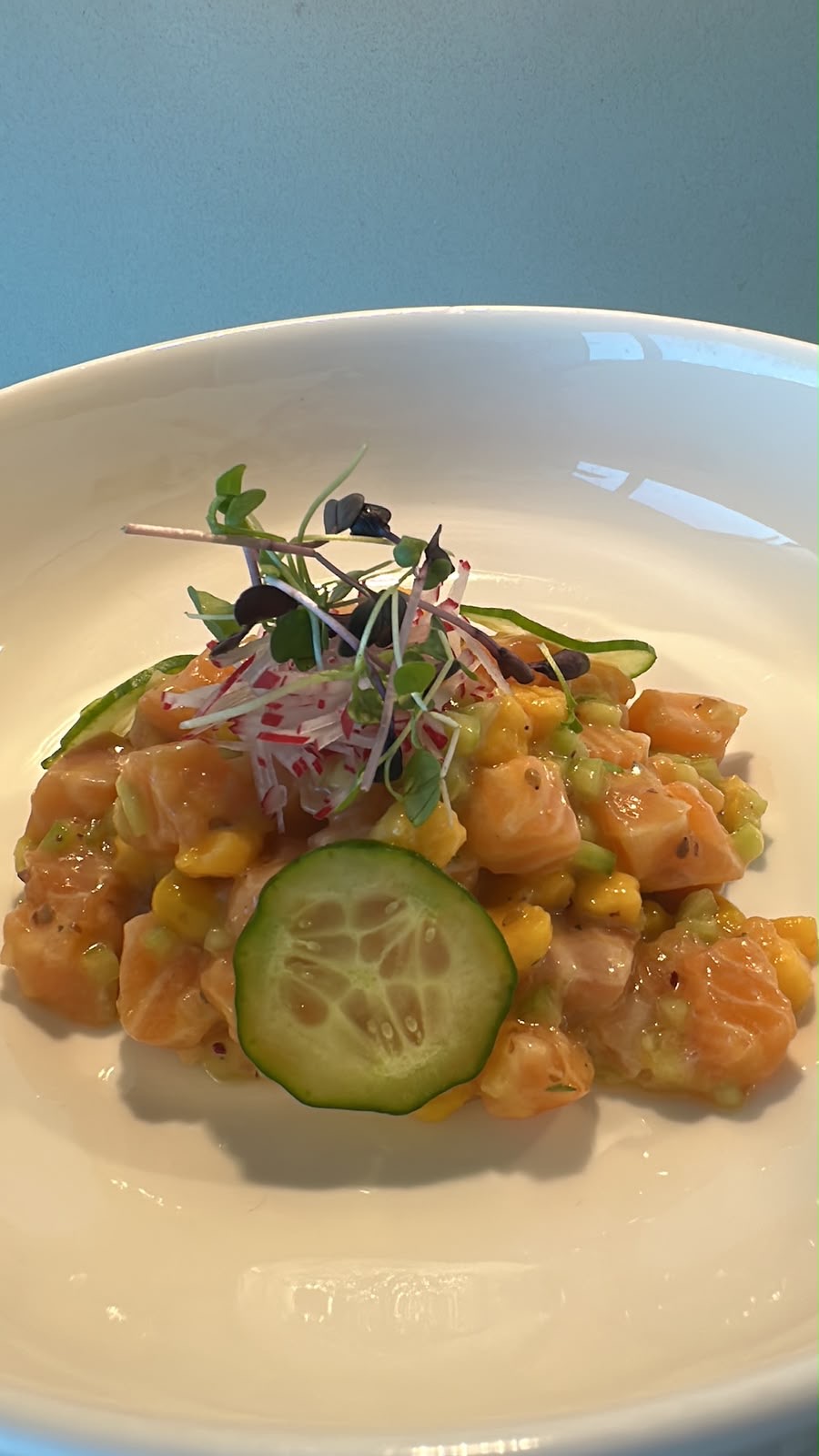 Fresh salmon tartare with avocado, corn and cucumber