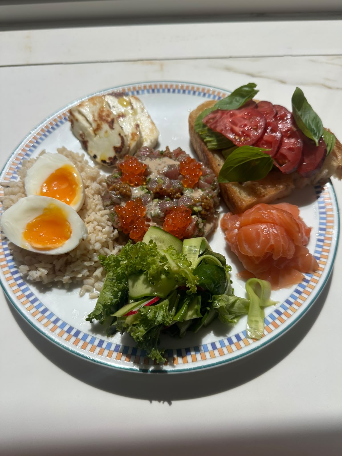 Breakfast plate with eggs, tartare, smoked salmon and avocado toast